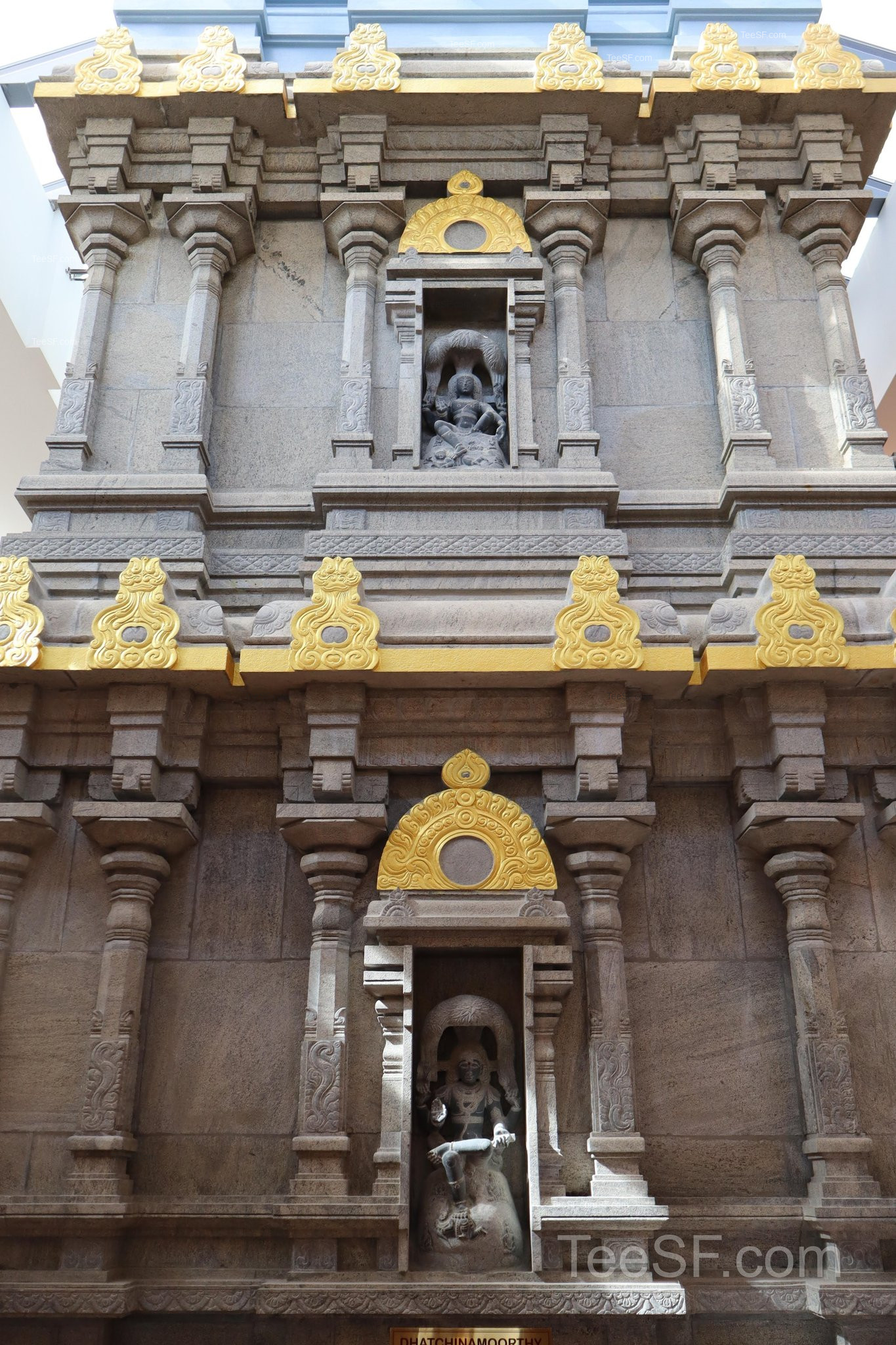 A vertical view of the temple facade with carved stone and gold trim.